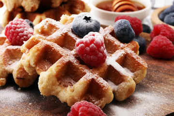 Traditional belgian waffles with fresh blueberries, sugar and raspberries.