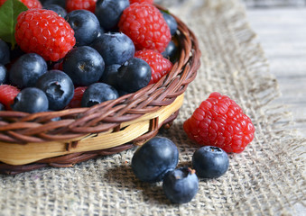 Fresh organic blueberries and raspberries.
Freshly picked raspberries and blueberries in a basket on a burlap cloth background.Blueberry and raspberry.Healthy eating,diet concept.Selective focus.