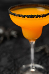 Halloween drink, orange cocktail on the dark background