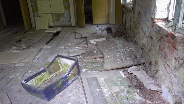 Chernobyl, Ukraine - 17th of June 2017: Visit to Zalesye village in Chernobyl zone - 4K Old  baby carriage in collapsing culture center, zoom out