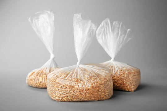 Wheat grass seeds in bags on grey background