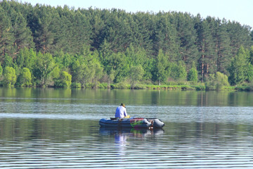 man in a boat fishing on lake - 177972121