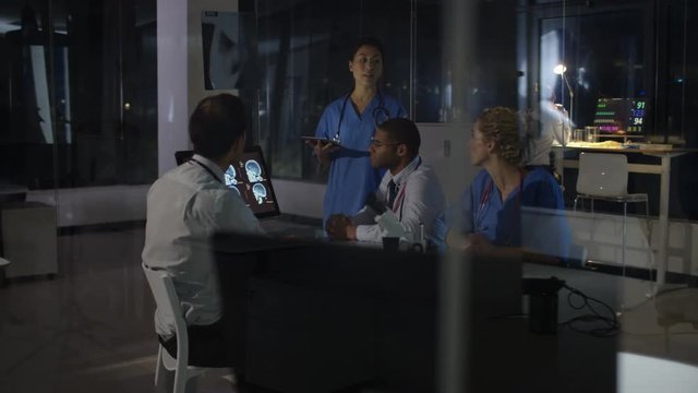  Medical team on night shift having a meeting, looking at patient scans