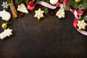 Christmas frame. Christmas gingerbread cookies and star, tree, spices (cinnamon, cloves and anise) on a brown slate or stone background. Flat lay, top view.