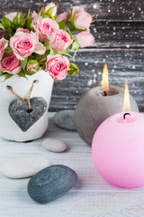 Heart, pink roses in concrete pot with candles