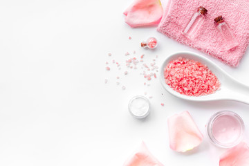 Spa products with rose oil. Cream, lotion and salt on white background top view copyspace