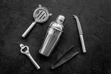 Instruments bartender. Shaker, strainer on black background top view