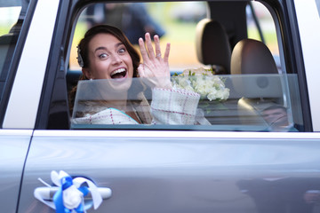 Portrait of a bride in a wedding limousine with a bouquet of flowers
