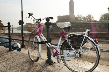 A bicycle is parked in a beautiful city. Bicycle on the background of the cityscape.