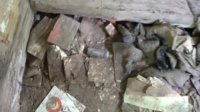 Chernobyl, Ukraine - 17th of June 2017: Visit to Zalesye village in Chernobyl zone - 4K Picture of USSR arms in book on the ground in abandoned village house