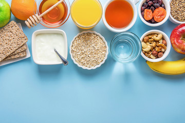 Healthy Food Fiber Sources Digestion Breakfast Oatmeal Honey Fruits Apples Banana Orange Juice Water Green Tea Nuts. Light Blue Tabletop Border Composition Copy Space