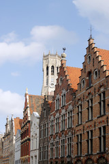 Obraz premium Ancient houses and a tower. The medieval architecture of Bruges.