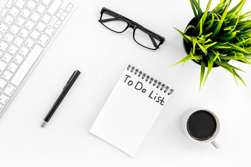 To do list for businessman in notebook on office table. White background top view