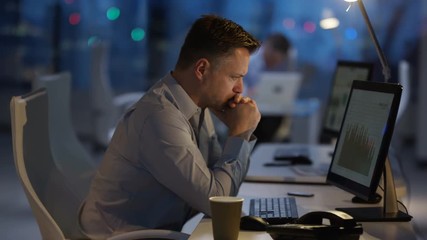 Exhausted businessman working late at the office - Powered by Adobe