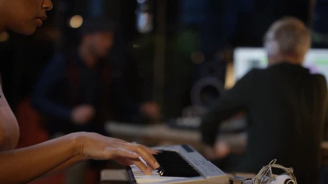  Band recording a track in home studio with technician at the mixing desk