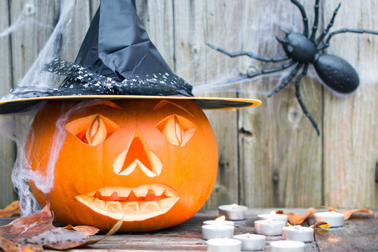 Gruseliger Halloween K&uuml;rbis mit Hut und Spinne als Dekoration f&uuml;r den 31.Oktober