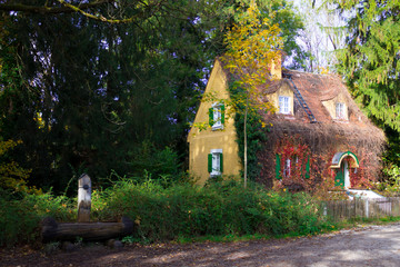 Fototapeta na wymiar Little wooden fairy tale house in a tree trunk. Autumn. Horizontal