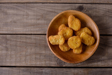 Chicken nuggets on wooden plate