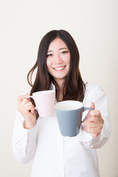 young asian woman giving mug cup