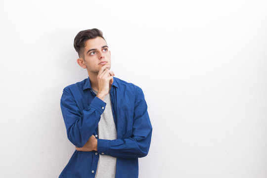young teenager with thoughtful expression on the white wall