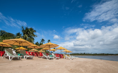 Fototapeta na wymiar Vacation concept - Beach chairs and umbrellas on tropical beach