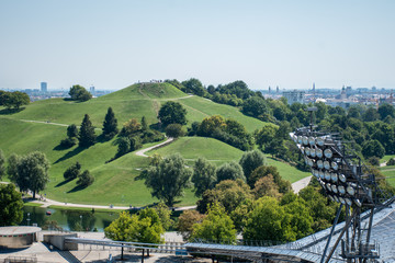 View from the Olympic stadium on an artificial pond and green field, in the German city munich.