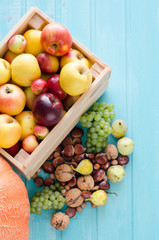 Apples, grapes and nuts on wooden background.