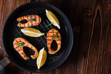Grilled salmon steaks in cast iron pan.