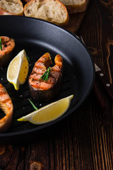 Grilled salmon steaks in cast iron pan.