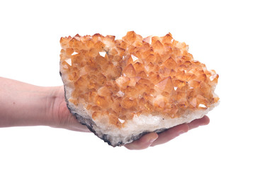 Citrine druzy cluster in woman's hands isolated on white background