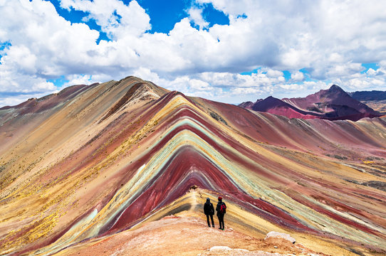 Tourists couple stand and look afar at Rainbow Mountains, Cusco, Peru