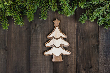 Christmas fir tree branches with christmas tree ornaments on dark rustic wooden background with copy space for text