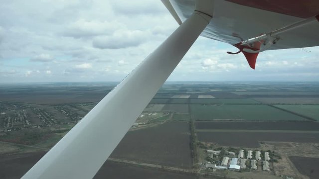 View From A Small Plane Of Grey Storm Clouds Over An Open Landscape Below In A Concept Of Flying And Aviation