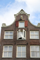 Fototapeta na wymiar amsterdam house window with curtain blowing in the wind