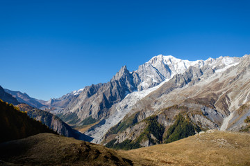 View of mountain peaks, of the Mont Blanc massif and coniferous forests in autumn, Val Ferret, Aosta valley, Italy