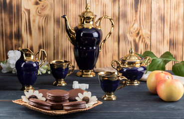 coffee on the table with background with cakes and apples