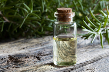A bottle of rosemary essential oil with rosemary twigs
