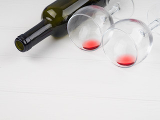 a wine bottle lies, next to two glasses with remnants of red wine, the concept of the holiday