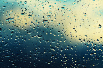 Rainy wet cold sky eco seasonal natural abstract background with water drops and sun spot