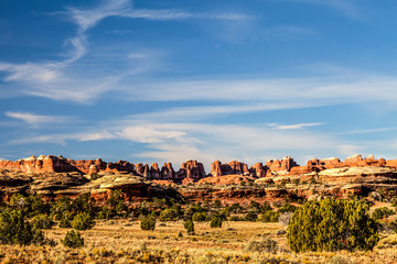 Fototapeta na wymiar The late afternoon sun lights up the beautiful land formations on the Chesler Park Trail in the Needles District of the Canyonlands National Park in Utah.