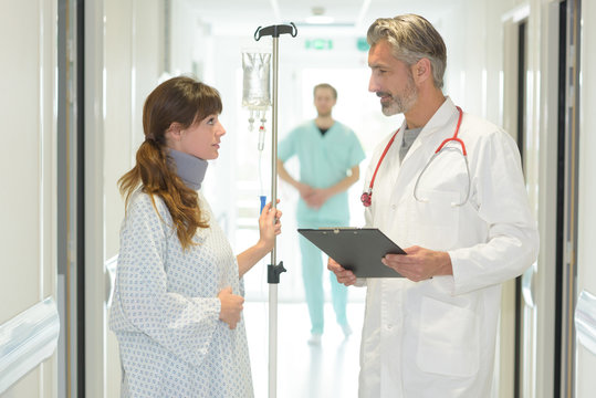 Male Doctor With Clipboard And Young Female Patient