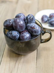 blue plum lies in a glass on a table