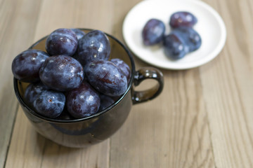 blue plum lies in a glass on a table
