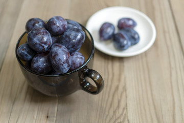 blue plum lies in a glass on a table