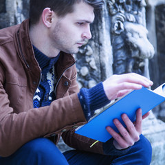 Young man relaxing and reading a book.