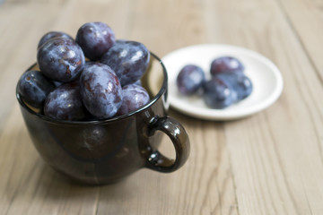 blue plum lies in a glass on a table