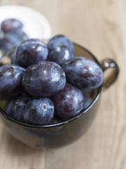blue plum lies in a glass on a table