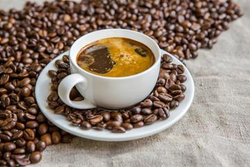 Cup of hot coffee on the table. Morning coffee. Composition of coffee beans.