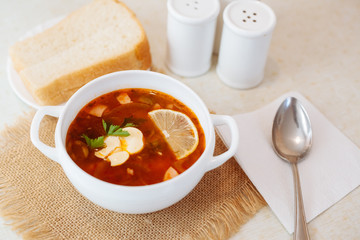 Meat Soup Solyanka, on a wooden table.