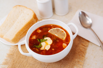 Meat Soup Solyanka, on a wooden table.